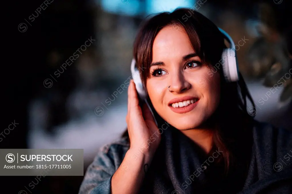 Attractive woman listening to music through headphone in forest