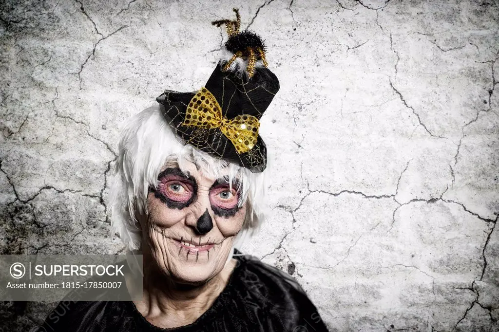 Portrait of senior woman with sugar skull make-up and fancy hat