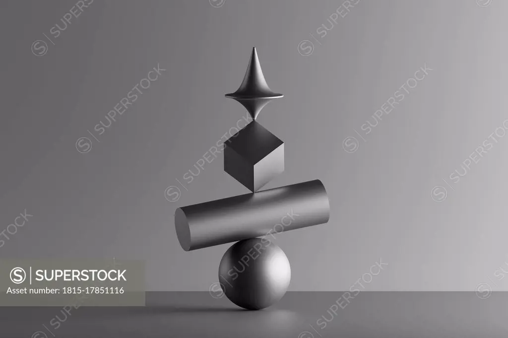 Three dimensional render of metallic top spinning on top of geometric cube,  cylinder and sphere - SuperStock