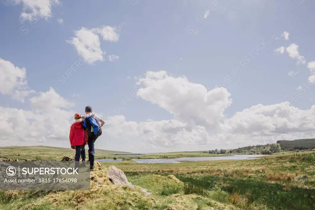 Back view of two brothers looking at view, Cairngorms, Scotland, UK