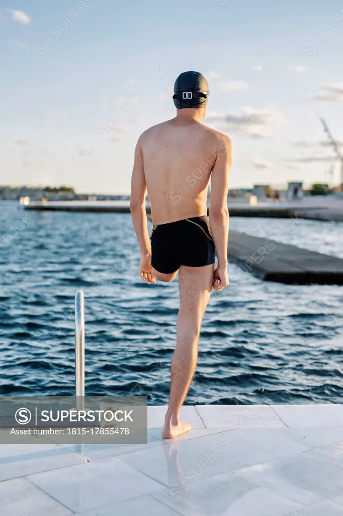 Disabled man looking at sea while standing on promenade during sunny day