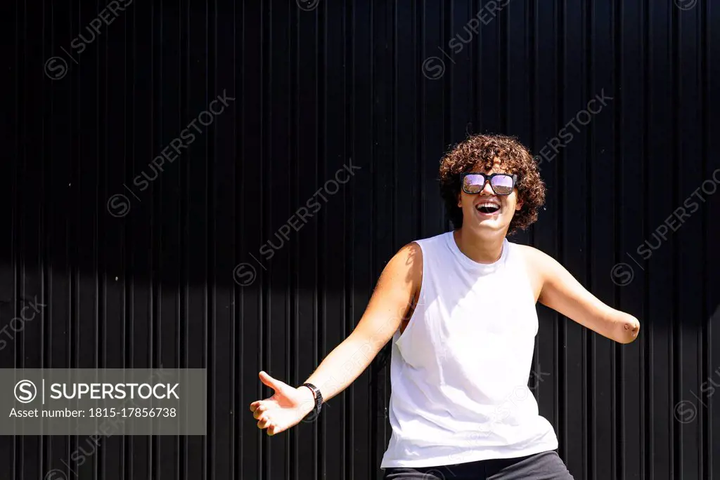 Happy amputee boy dancing against shutter