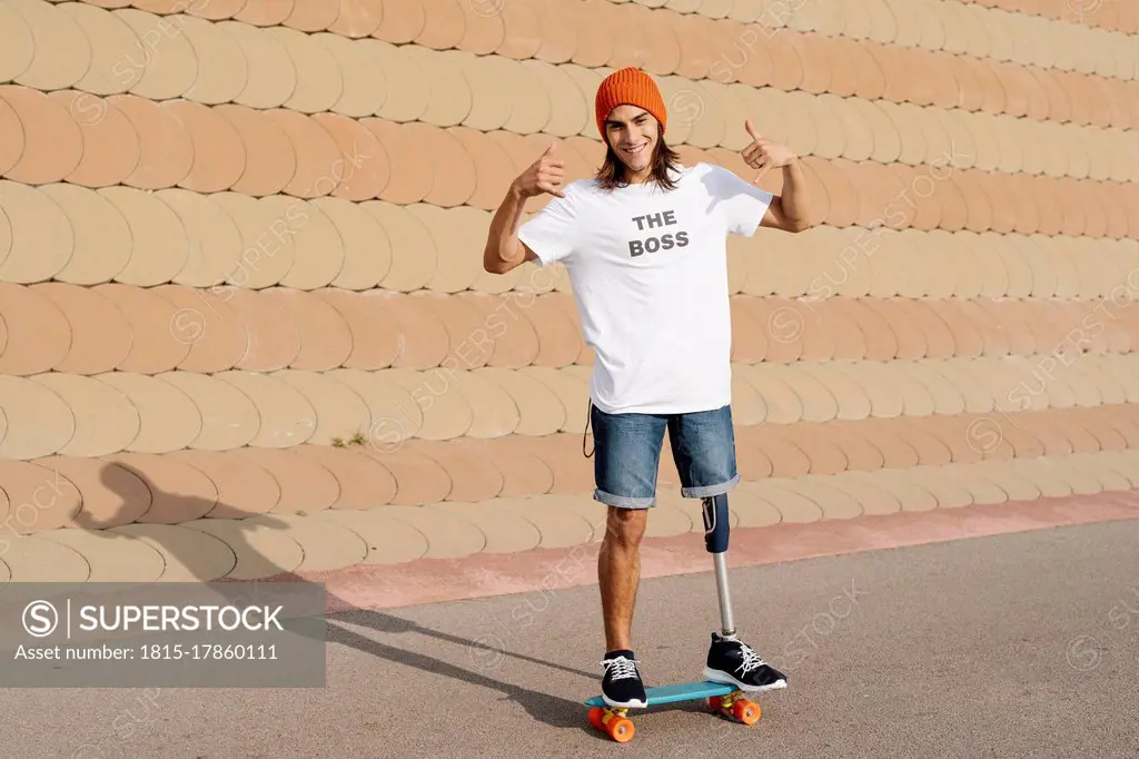 Young disabled man standing on skateboard at sports court