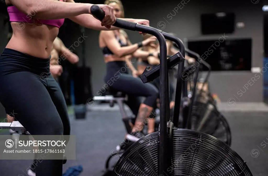 Athletes exercising on fitness bike in gym