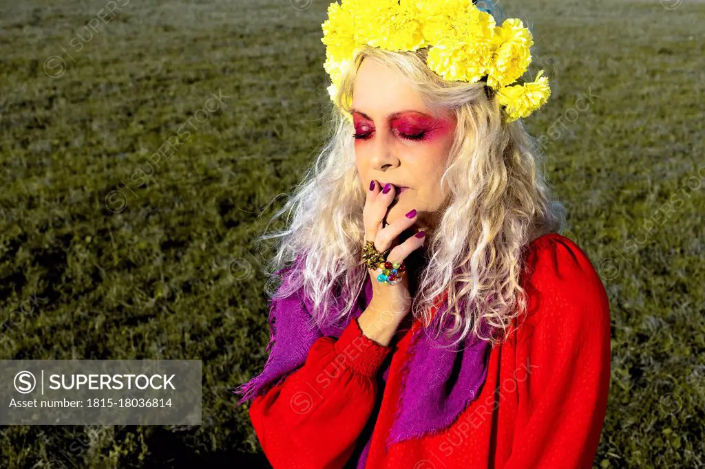 Senior woman with make-up sitting on grass