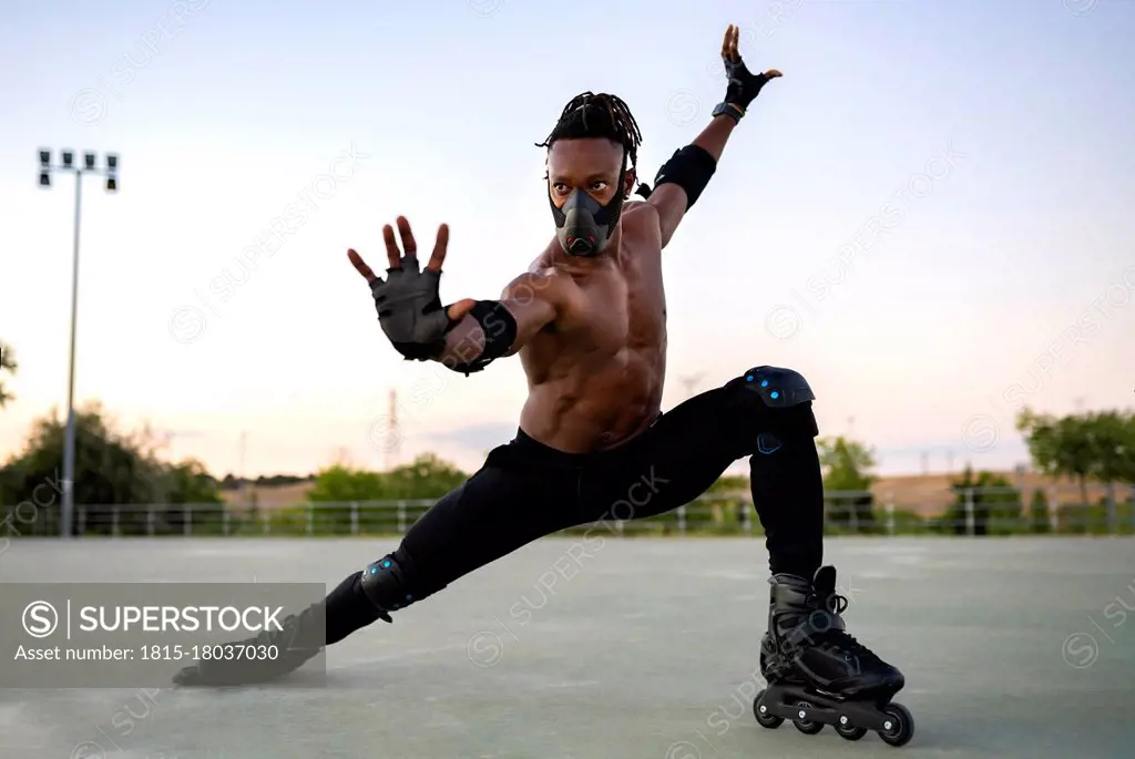 Man wearing protective face mask stretching while standing on ground