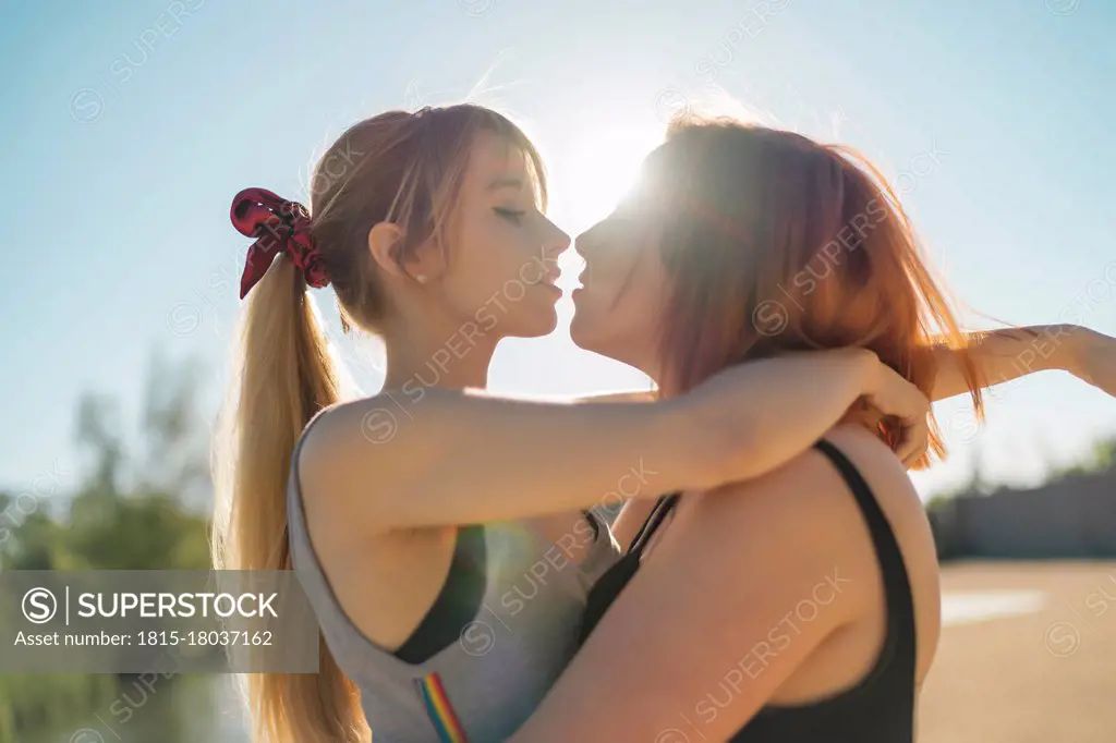 Lesbian couple doing romance while standing against sky