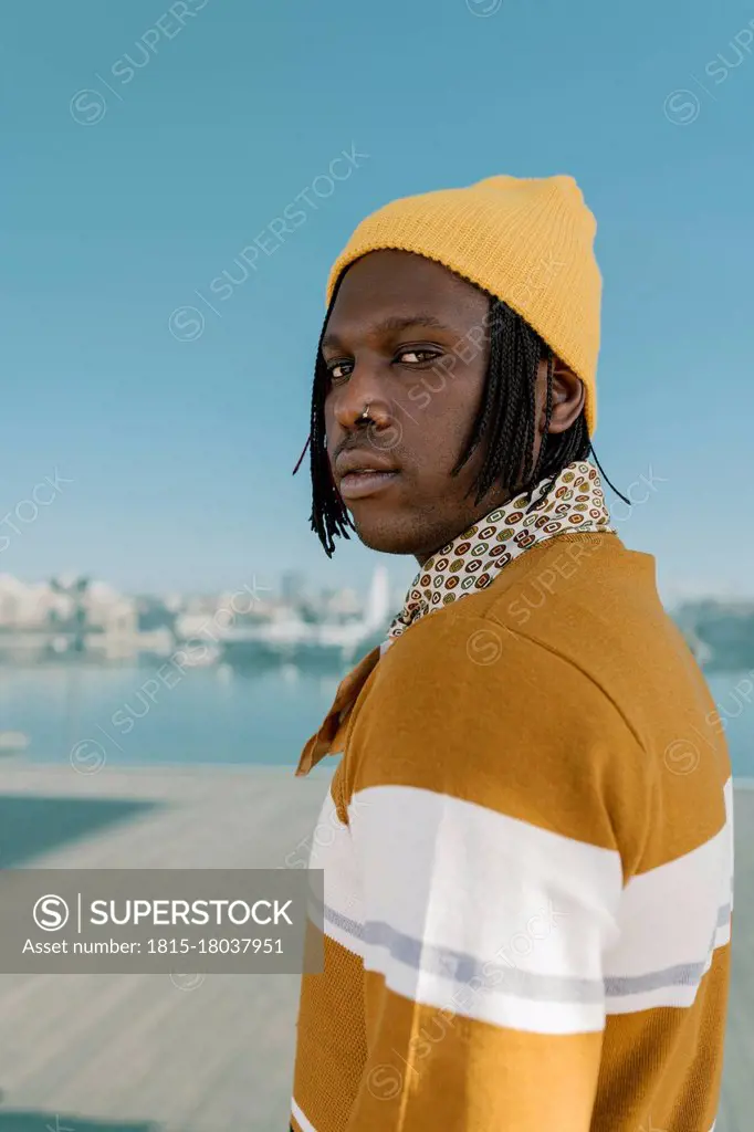 Man in yellow knit hat against glass wall