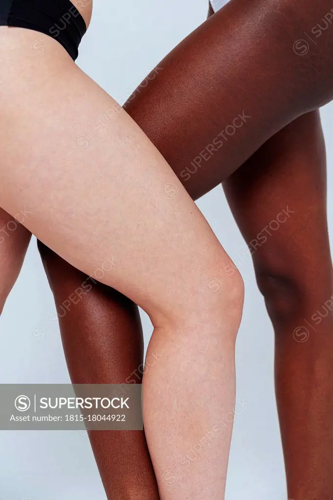 Women standing with legs crossed at knee in studio