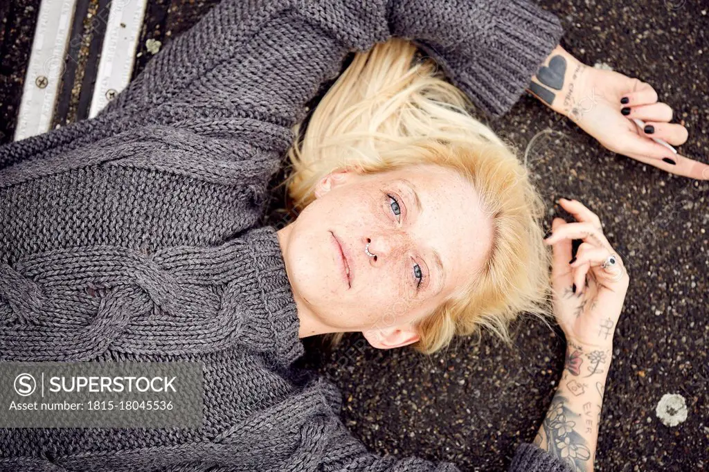 Young woman lying down at parking lot