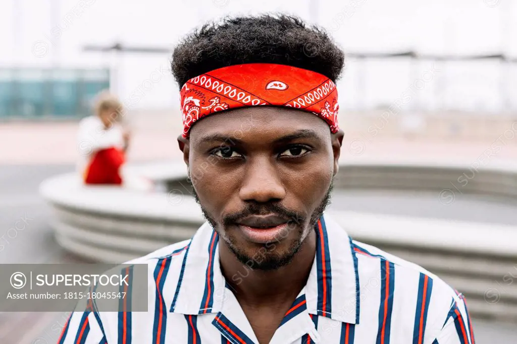 Man wearing headband staring while sitting outdoors