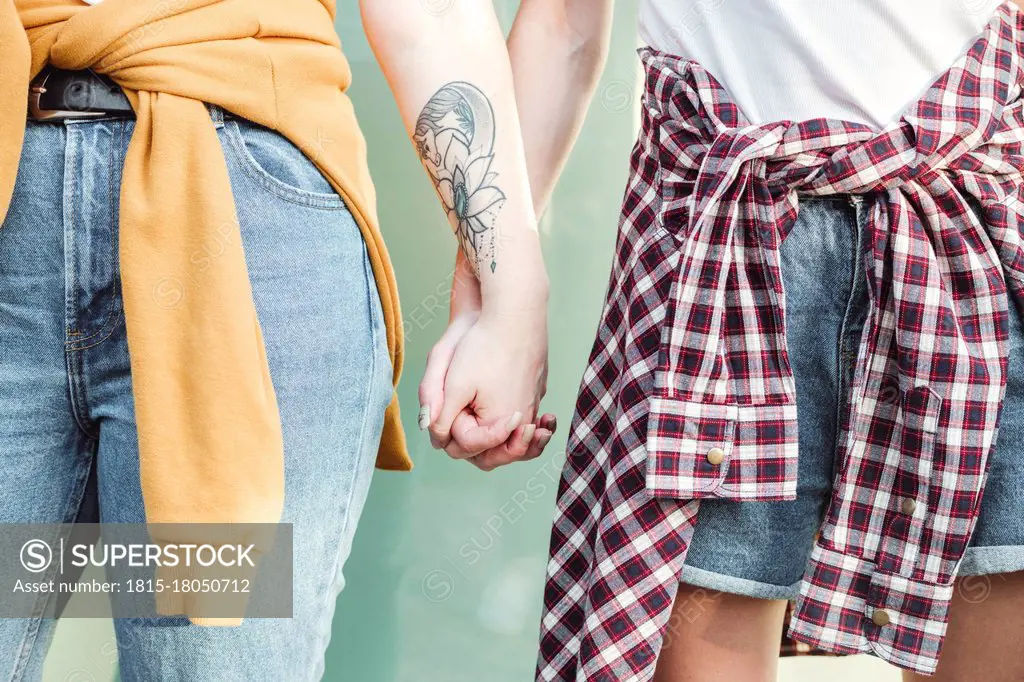 Female friends holding hands of each other