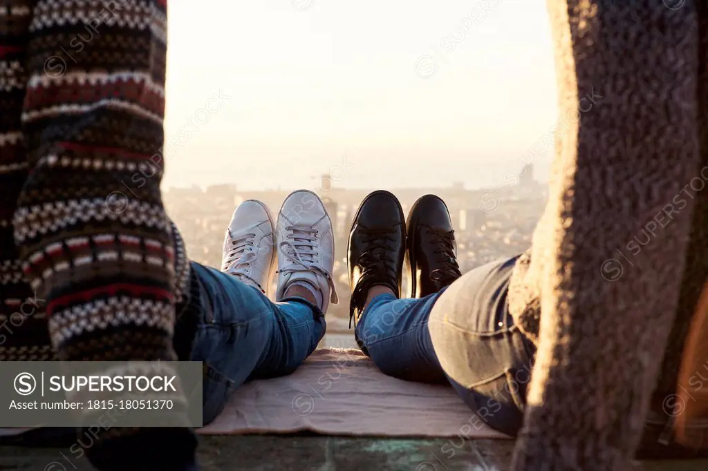 Legs of gay couple wearing shoes sitting on observation point, Bunkers del Carmel, Barcelona, Spain