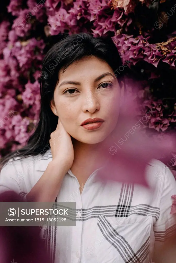 Sensual woman standing against pink flower at park