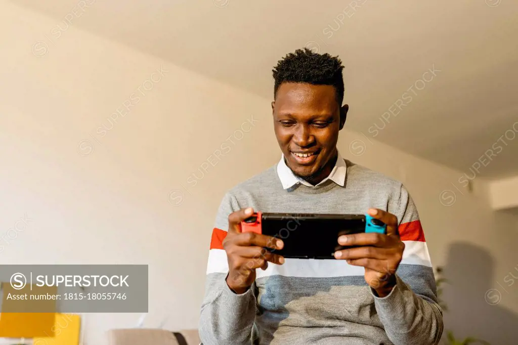 Male entrepreneur playing video game at home during break from work