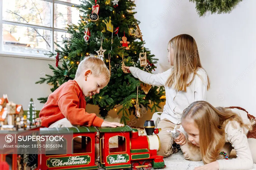 Siblings playing with toys at home during Christmas