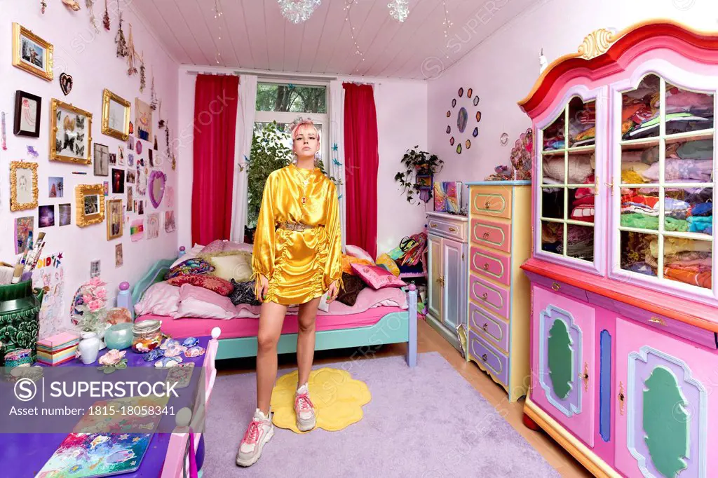 Beautiful woman wearing yellow dress in flashy bedroom at home