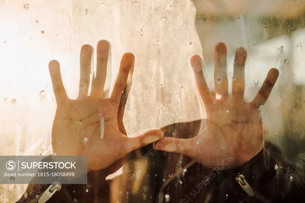 Man's hand touching dirty glass