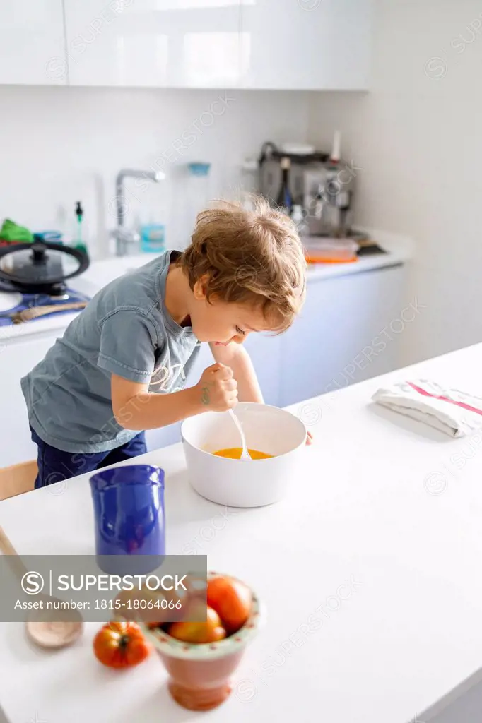 Little boy cooking in kitchen at home