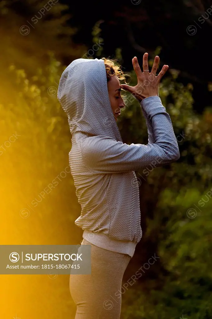 Sportswoman meditating while standing at park