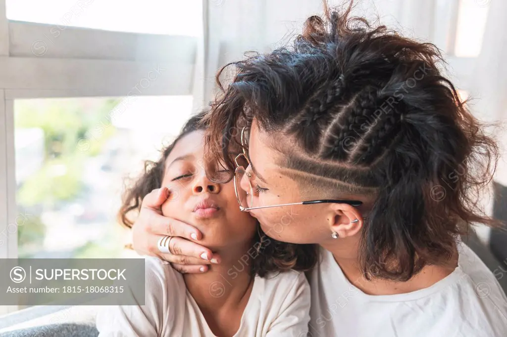 Mother kissing daughter on cheek