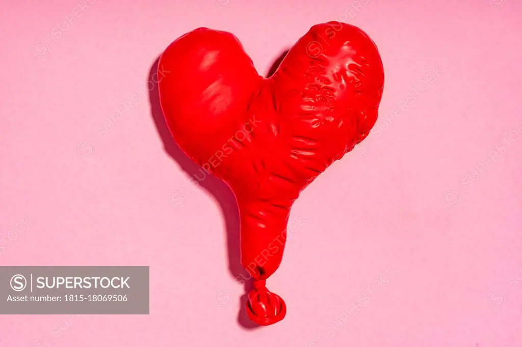 Studio shot of red heart shaped deflated balloon