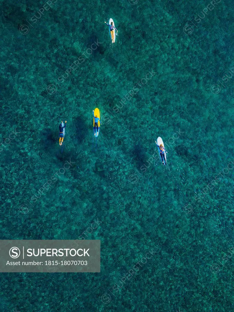 Aerial view of surfers swimming in turquoise waters of Arabian Sea