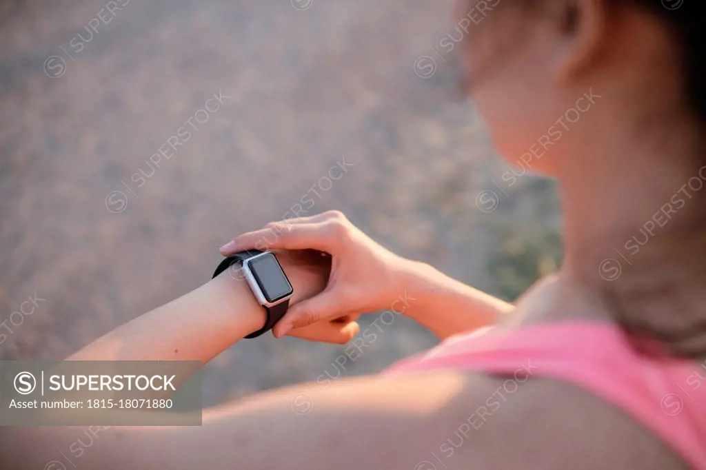 Fit young athlete checking tome on smart watch