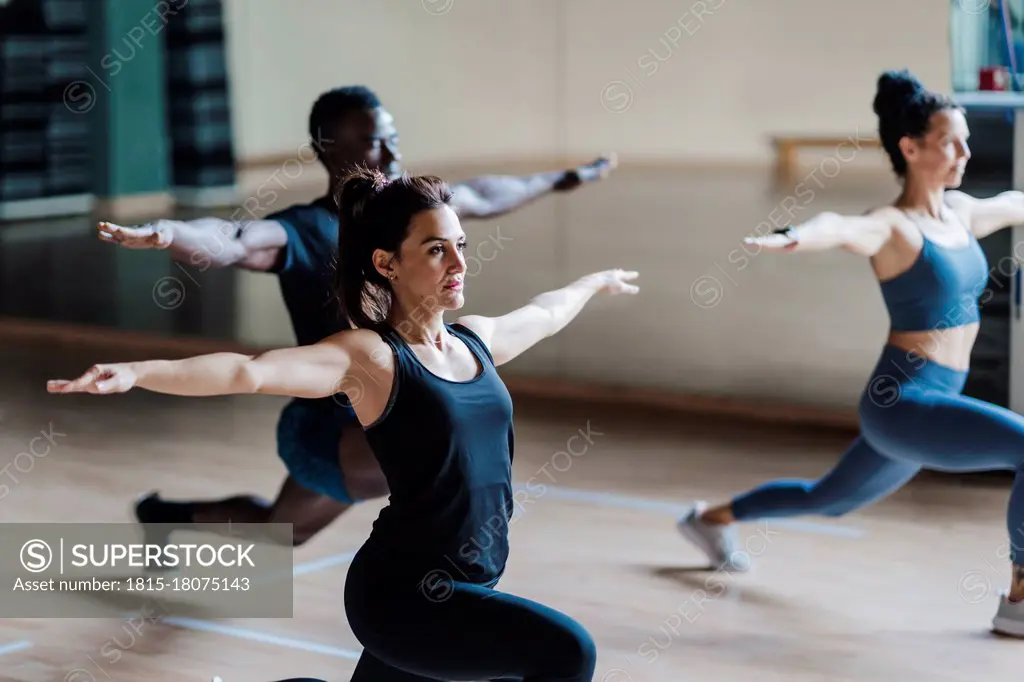 Female and male athlete friends in warrior position in gym