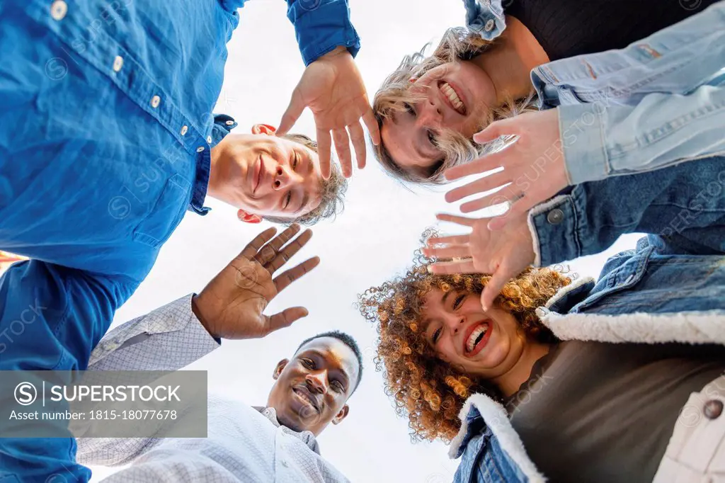 Smiling male and female friends waving hands