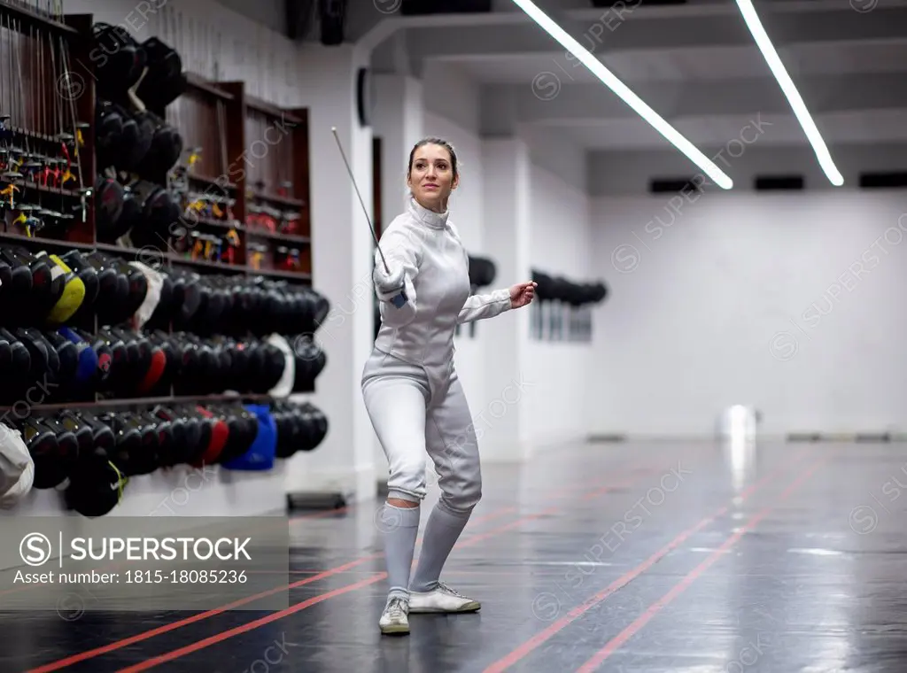 Woman¶ÿin fencing outfit practicing at gym