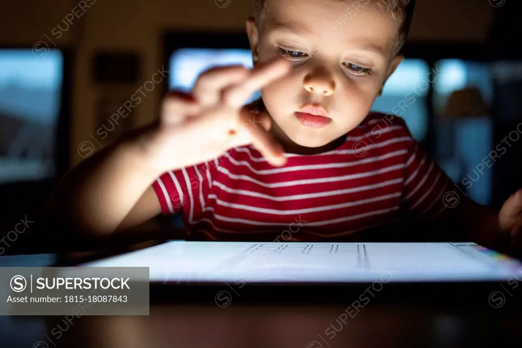 Cute boy using digital tablet at home