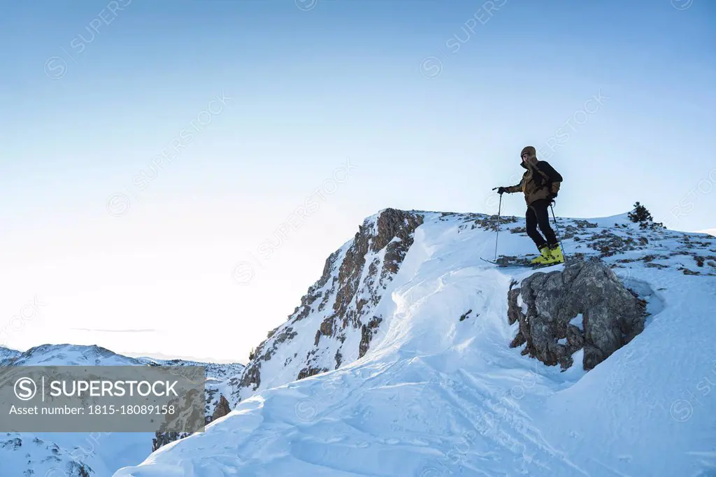 Male mountain climber on mountain summit against sky
