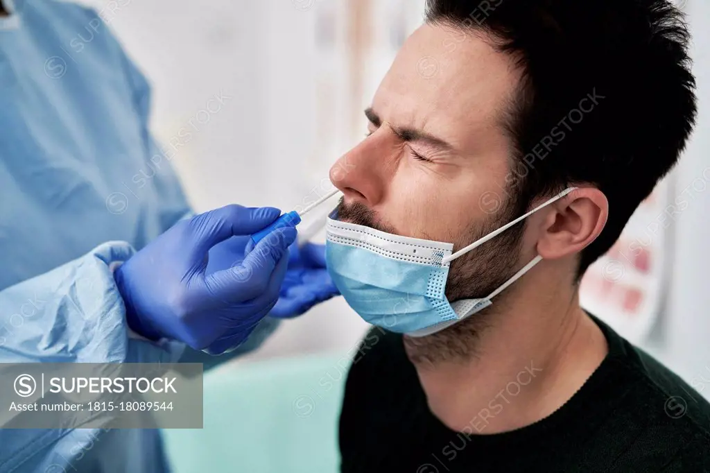 Medical professional collecting sample using nasal swab for COVID-19 test