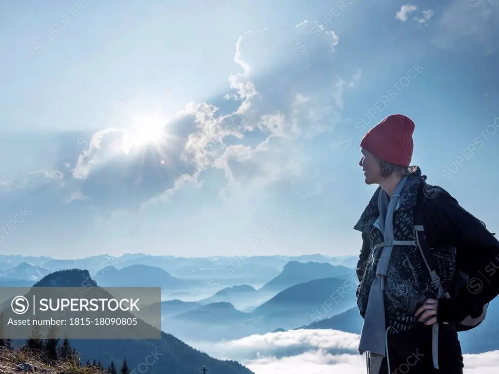 Female tourist standing on Heuberg mountain against cloudy sky during sunny day