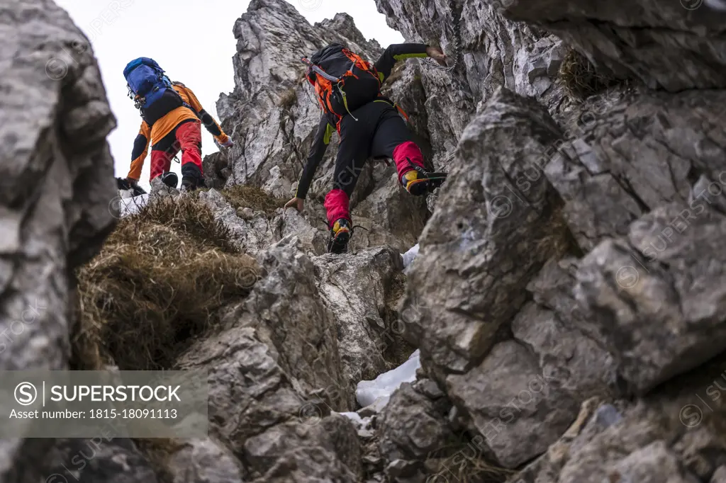 Men with backpack climbing on rocks