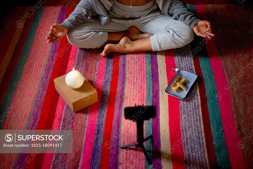 Spiritual woman meditating during video call at home