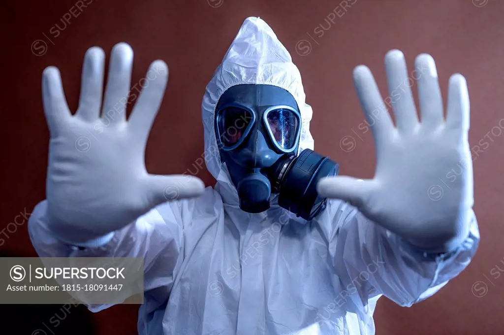 Mature man in protective workwear gesturing stop sign