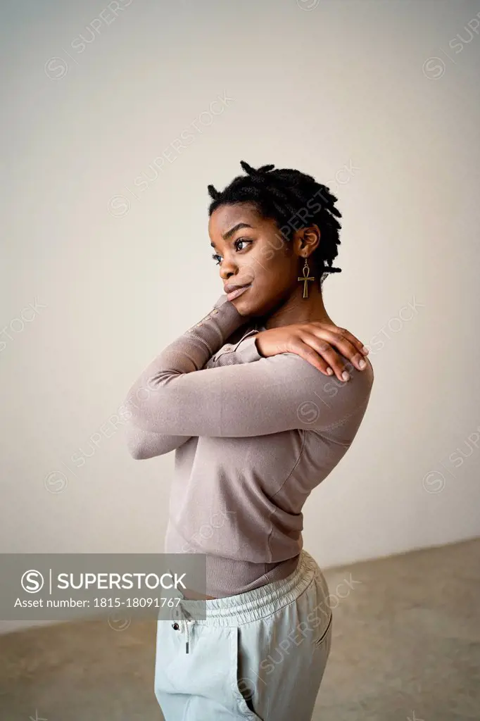 Young woman self hugging at home