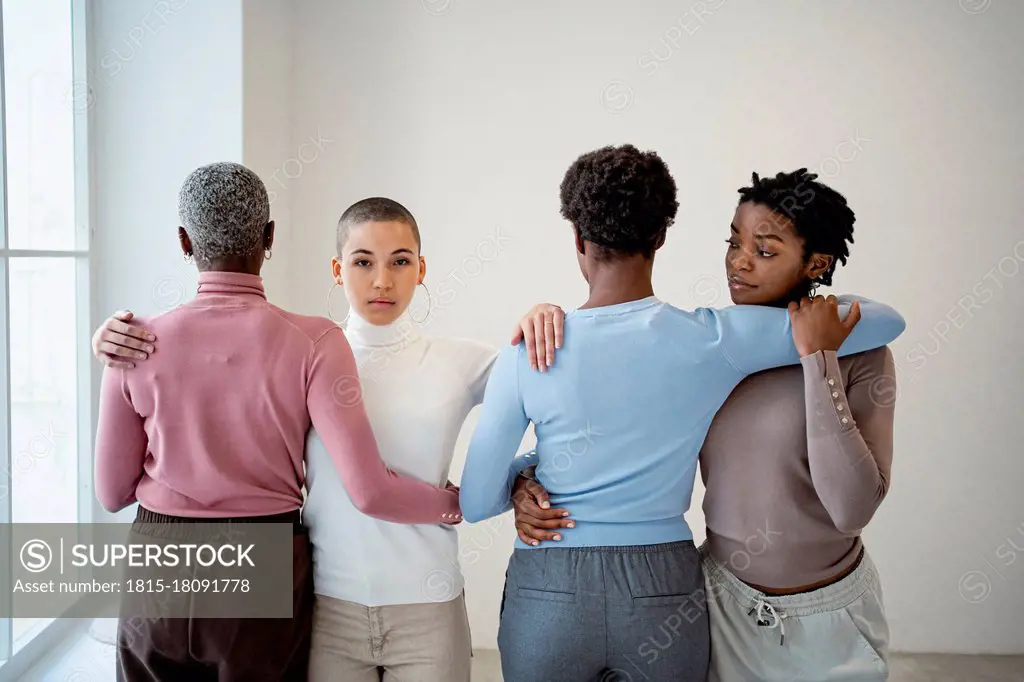 Female friends embracing each other in living room