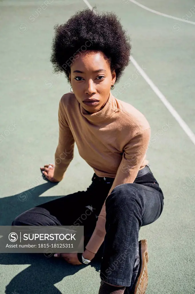 Young woman sitting at sports court