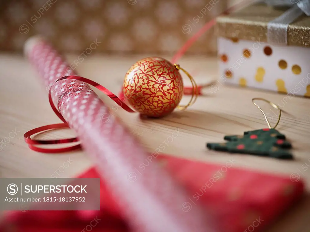 Gift wrapping paper with ribbon and Christmas decoration on table