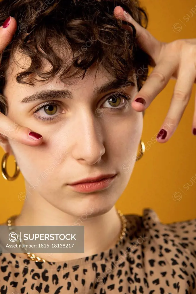 Young woman with hands touching head while looking away