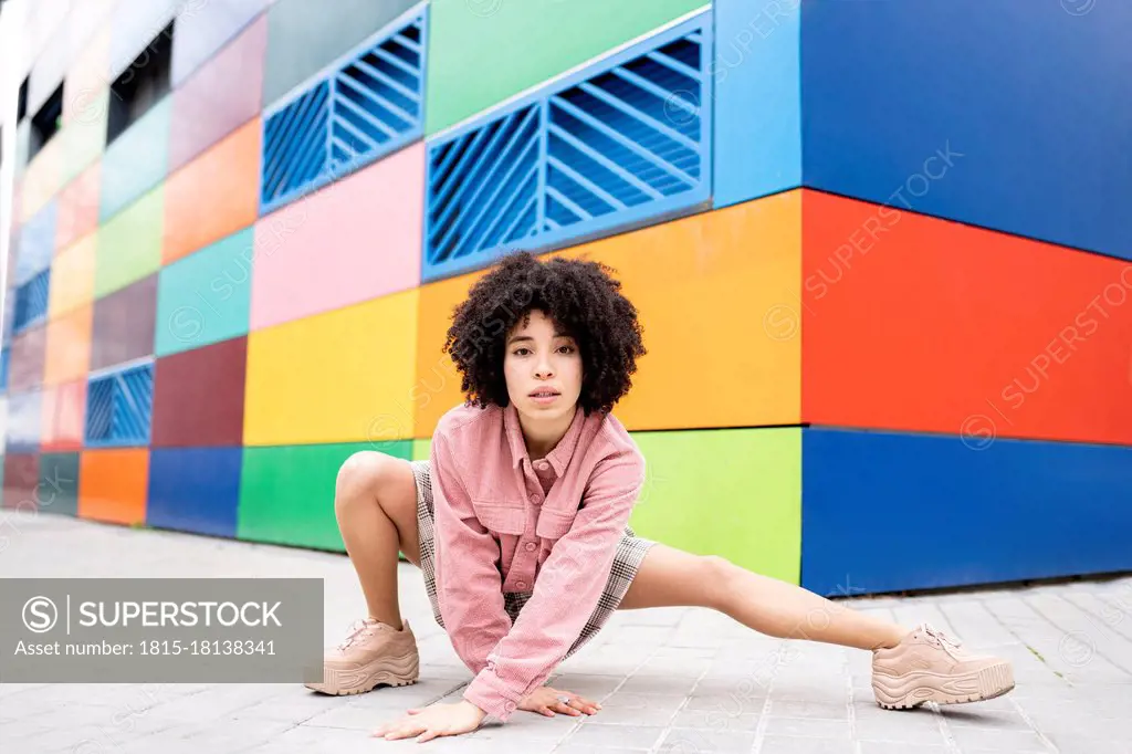 Female dancer dancing while crouching on footpath