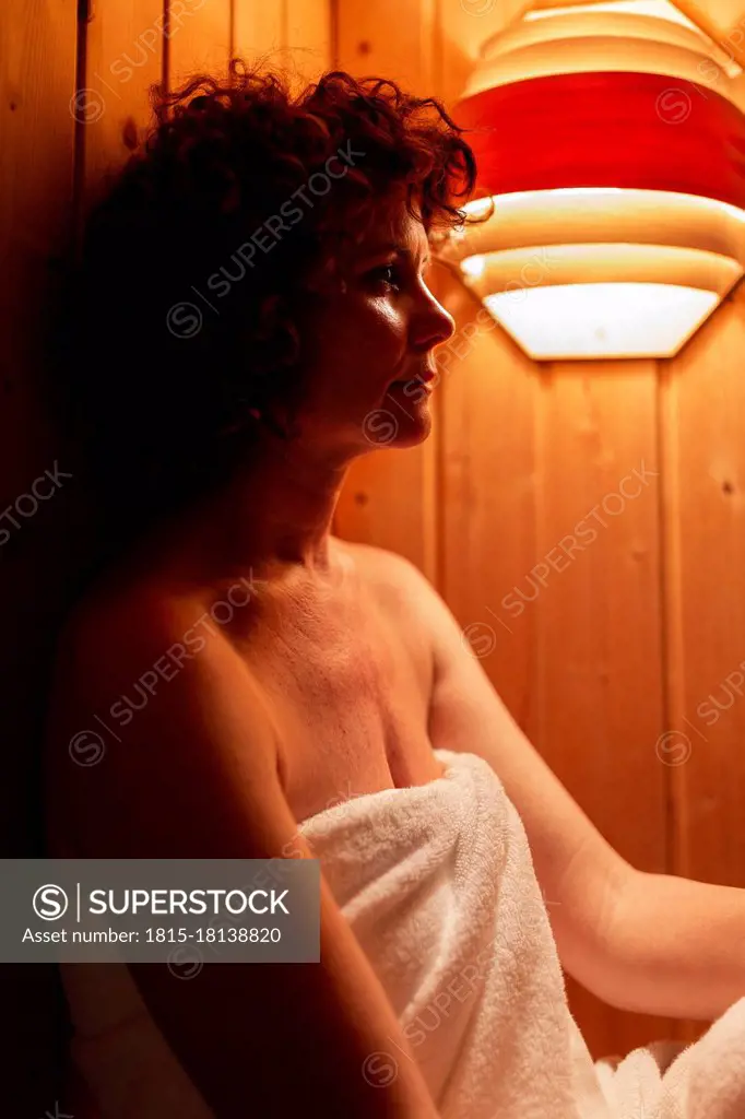 Three Mature Women Wearing Towels Sitting In A Sauna High-Res