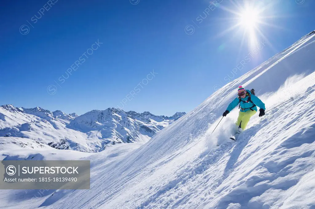 Sun shining over woman skiing in Arlberg massif