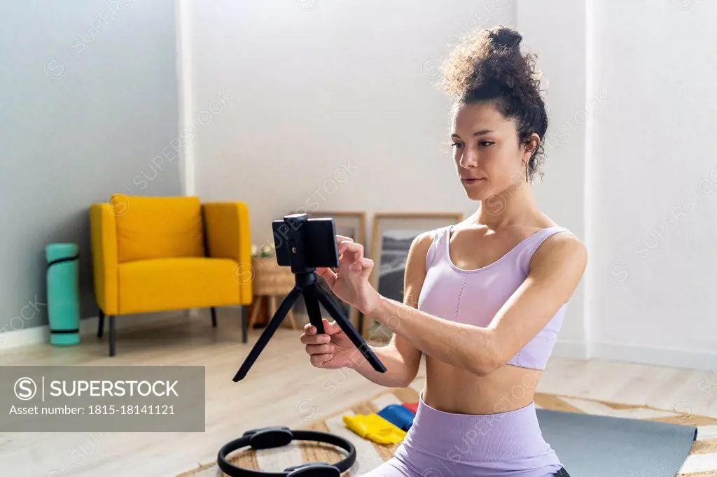 Female vlogger touching mobile phone at home