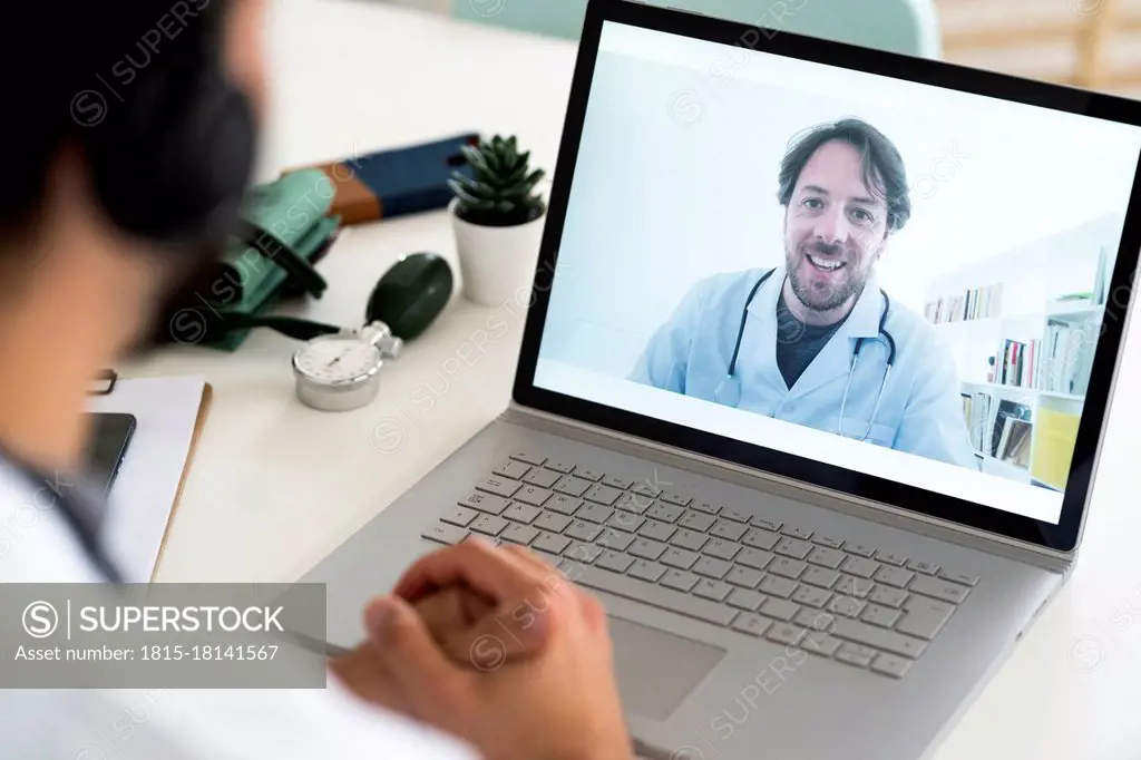 Male healthcare worker discussing with doctor through video conference