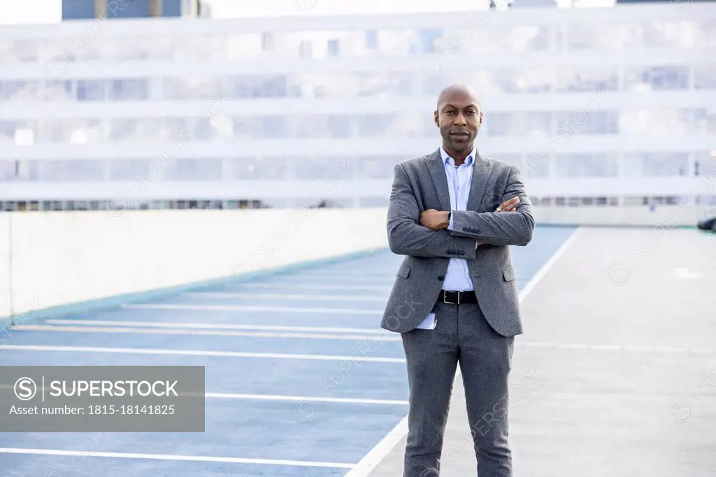 Confident businessman in suit standing at terrace parking