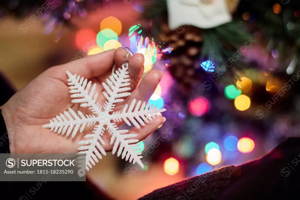 Woman's hand holding Christmas ornament, close-up